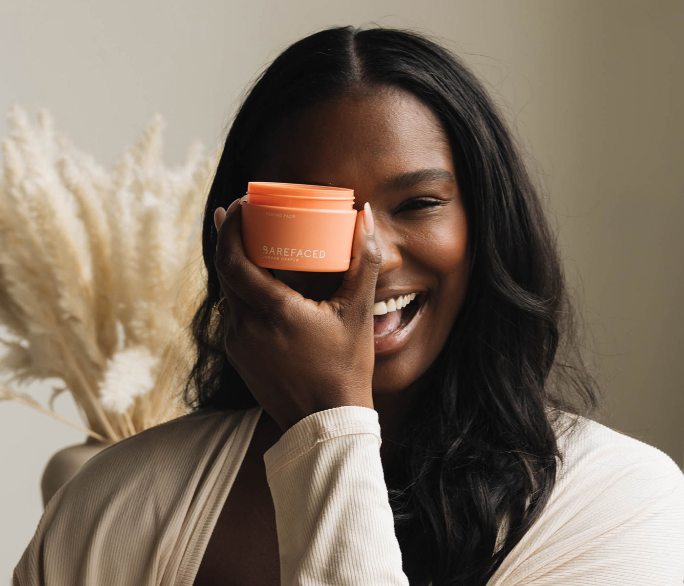 Woman smiling holding Barefaced Toning Pads
