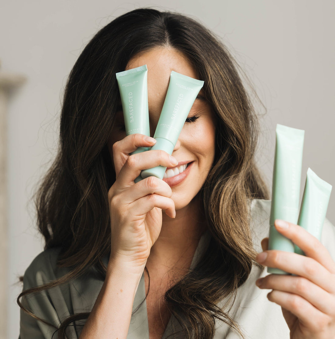 Jordan Harper holding RetinAL Skin Therapy to her face playfully