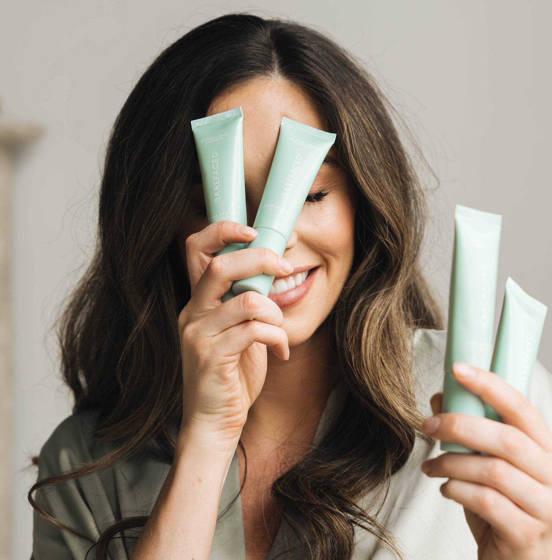 Jordan Harper holding RetinAL Skin Therapy to her face playfully