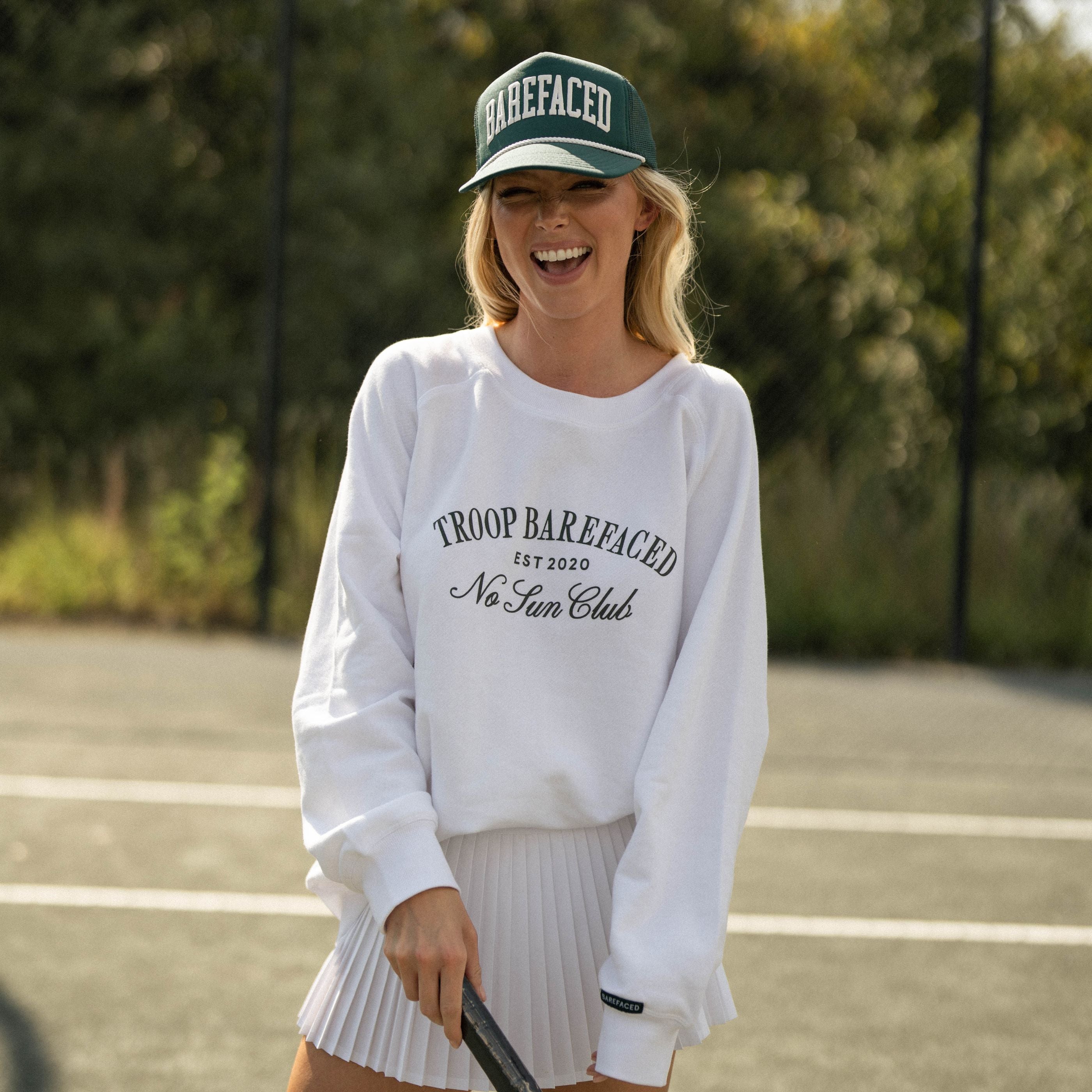 Woman wearing Barefaced Varsity Trucker Hat playing tennis