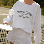 Woman wearing No Sun Club Crewneck sweatshirt playing pickleball
